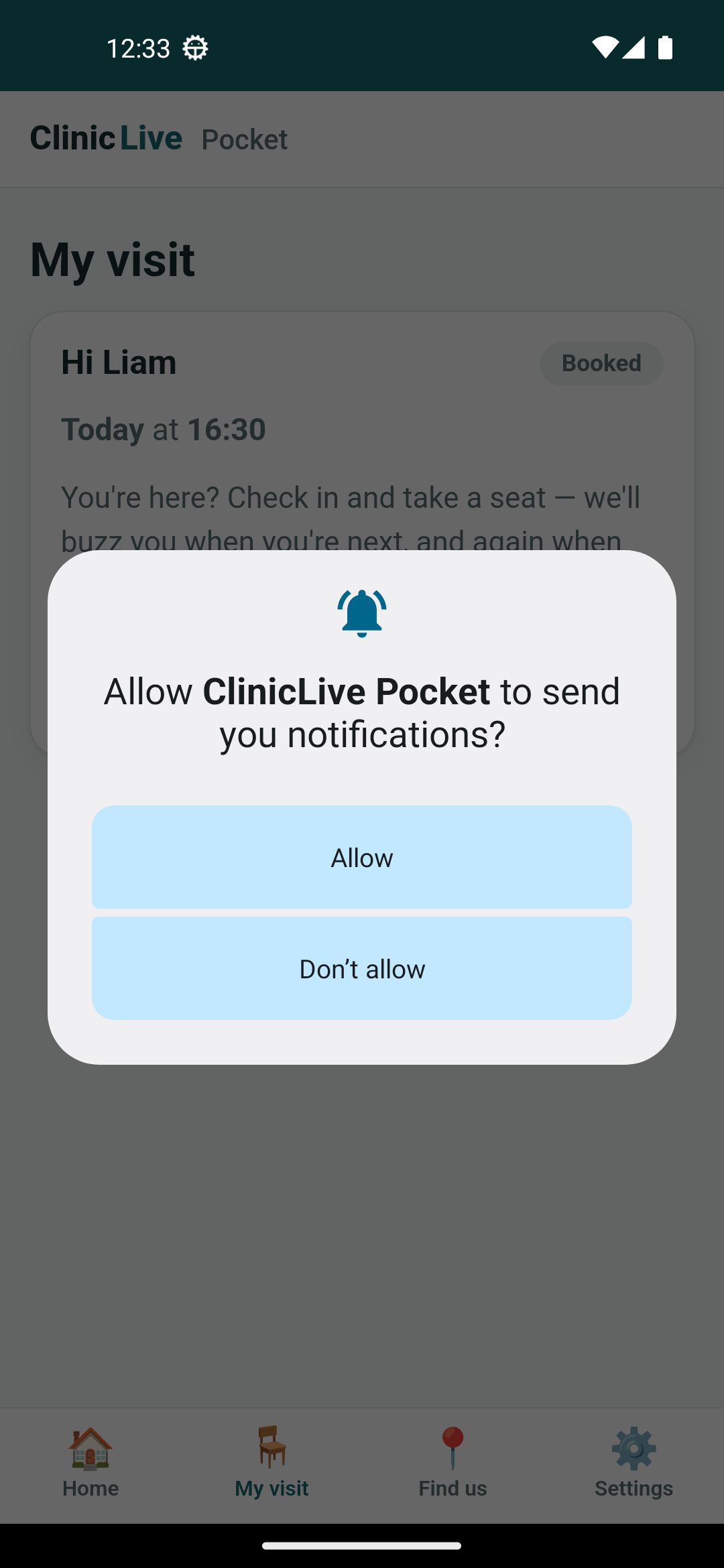 The My visit screen on the Android emulator, dimmed behind a system dialog: a bell icon, 'Allow ClinicLive Pocket to send you notifications?', and two pale blue buttons, Allow and Don't allow. Behind it, Liam's booked visit for today at 16:30 and the start of the sentence 'You're here? Check in and take a seat — we'll buzz you when you're next…'.