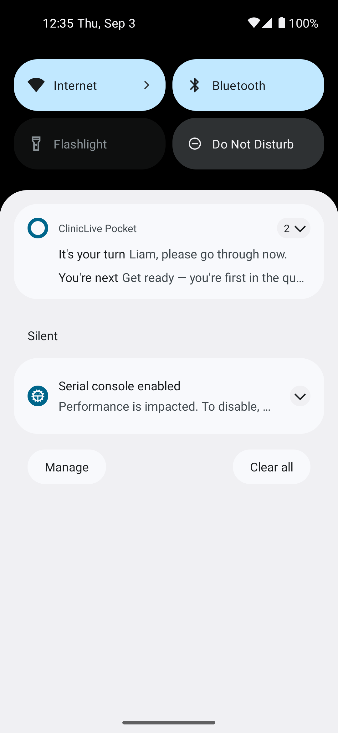 The Android notification shade at 12:35: quick-settings tiles for Internet, Bluetooth, Flashlight and Do Not Disturb, then a ClinicLive Pocket group of two notifications — 'It's your turn: Liam, please go through now.' and 'You're next: Get ready — you're first in the qu…' — and below, in a Silent section, the emulator's own 'Serial console enabled' notice.