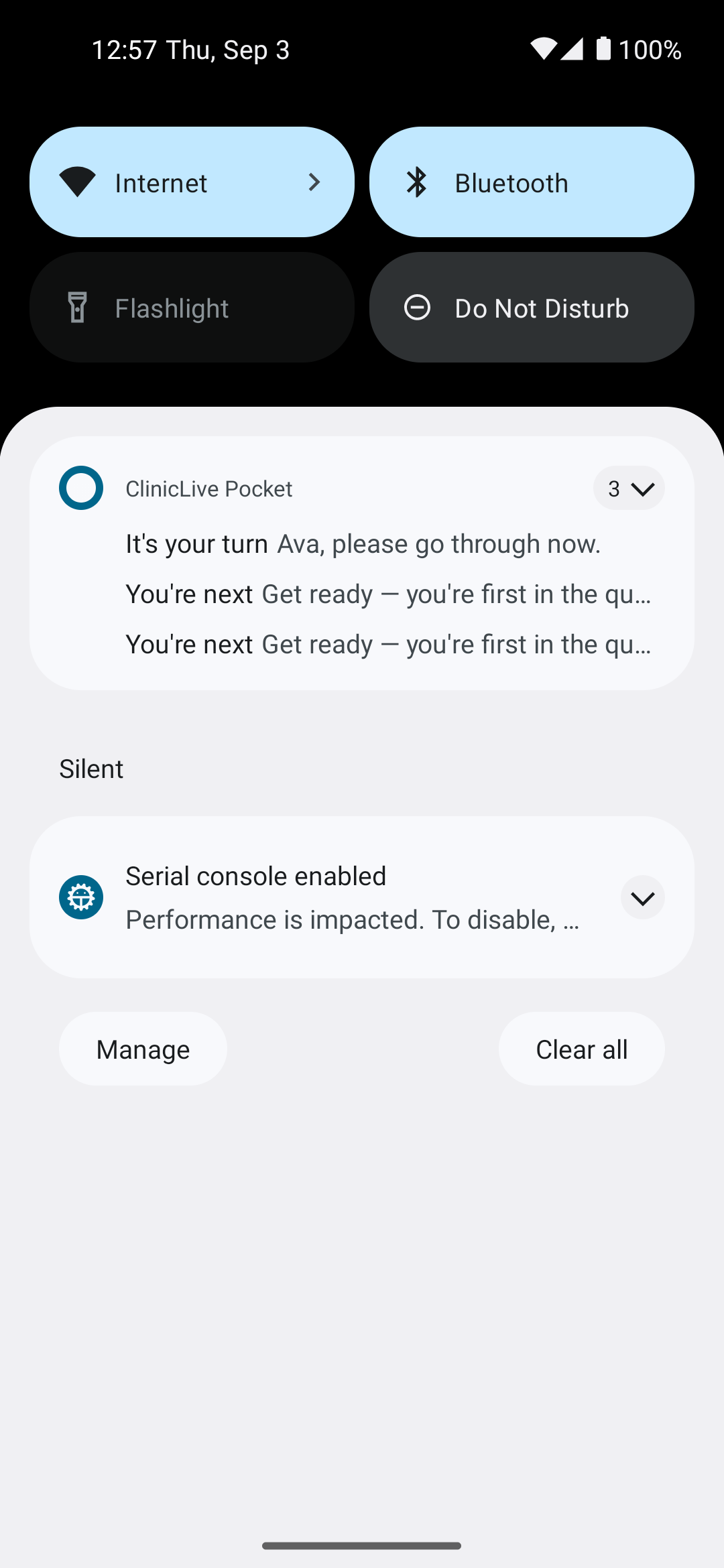 The Android notification shade at 12:57 with a ClinicLive Pocket group of three: 'It's your turn: Ava, please go through now.' on top, then two identical lines reading 'You're next: Get ready — you're first in the qu…'. Below, in a Silent section, the emulator's 'Serial console enabled' notice, and Manage and Clear all buttons.